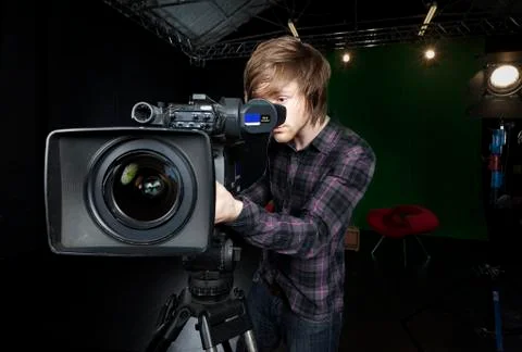 Man looks into viewfinder of a tv studio camera Stock Photos