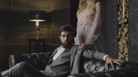 Man lounges on sofa with hand on back lady hand on shoulder Stock Footage 103934847