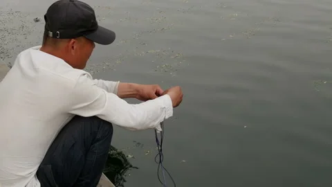 Man lower the string into the water Video stock 102296707