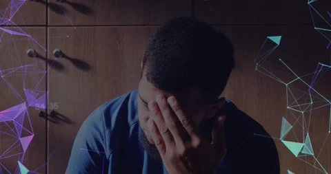 Man lowering gaze and rubbing face from fatigue, tech showing purple teal Stock Footage 330509276
