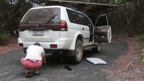 Man lowering a vehice with jack Stock Footage 70766798