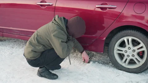 Man Lowers Car Jack with Spanner in Snowy Winter Setting Stock Footage 310187981