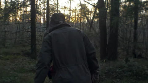 Man lumberjack out of the forest at sunset Stock Footage 97902537