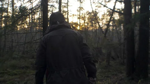 Man lumberjack out of the forest at sunset Stock Footage 97903755