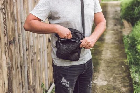 Man with luxury snakeskin python leather handbag. Bali island background. 写真素材