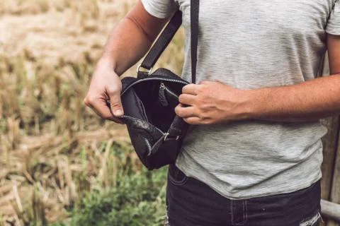Man with luxury snakeskin python leather handbag. Bali island background. Stockfoto's