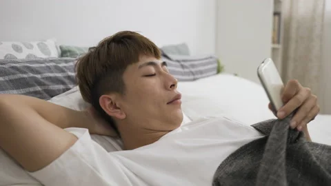 Man lying awake on bed with an arm behind 库存影片 200443358