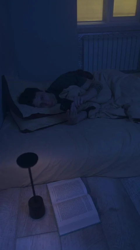 Man lying awake at night, mobile phone screen keeping him awake, blue light Video stock 320247477