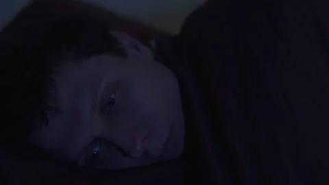 Man lying awake at night with open eyes, insomnia and anxiety in darkness Stock Footage 324817544