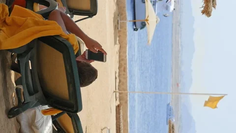 Man is lying on the beach couch under the umbrella Stock Footage 91161081