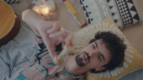 Man Lying on Bed and Looking at Sand Timer Stock Footage 235660679