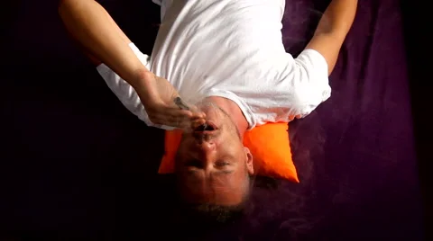 Man lying on bed and vapouring e cigarette. Stock Footage 53378554