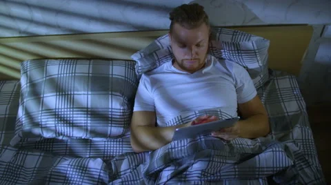 The man lying in a bed completes counting for work Stock Footage 58015410