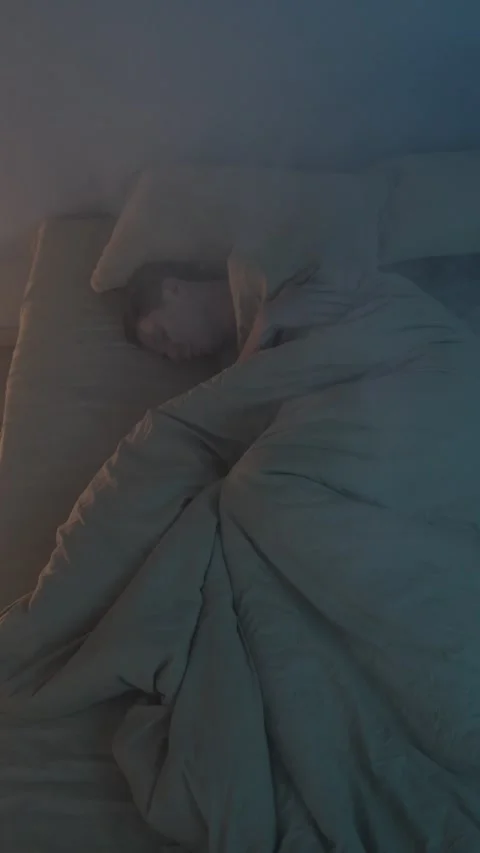 Man lying in bed coughing and struggling to breathe as smoke fills the room Stock Footage 299797869