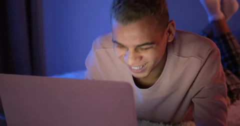 Man lying on bed in front on laptop Stock Footage 145289639