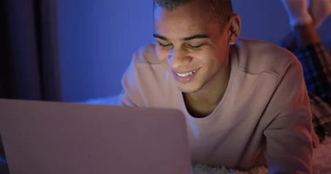 Man lying on bed in front of laptop Stock Footage 145292699