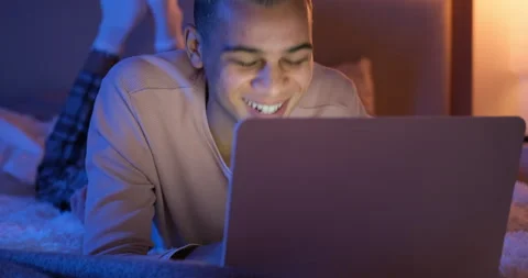 Man lying on bed in front on laptop Stock Footage 145293195
