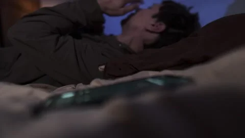 Man lying in bed ignoring phone call, emotional numbness, apathy, burnout Stock-Footage 321711701