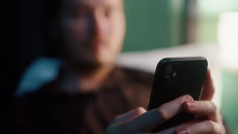 Man lying in bed at night scrolling smartphone screen 動画素材 319544294