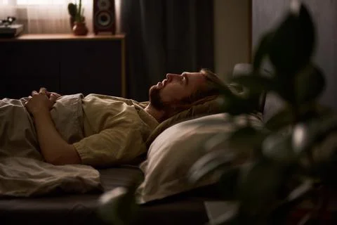 Man Lying in Bed Suffering from Insomnia and Sleep Disorder Stock Photos