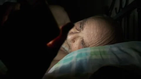 Man Lying in Bed Using Smartphone at Night in Dim Lighting Video stock 307739974