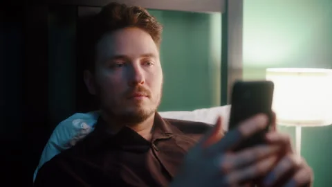 Man lying in bed using smartphone at night Vídeos de archivo 319545714