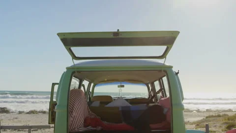 Man lying in camper van facing ocean while travel map animating guitar and Video stock 309097780