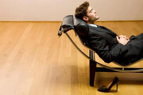 Man lying on chaise longue Stock Photos