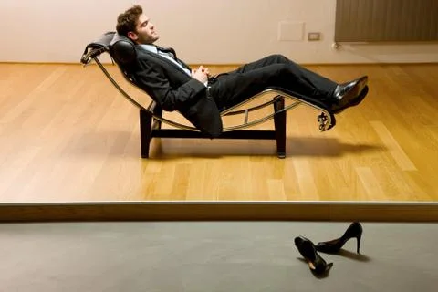 Man lying on chaise longue Stock Photos
