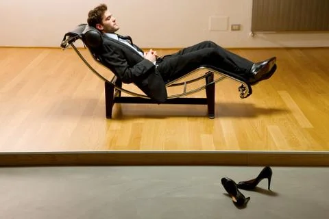 Man lying on chaise longue Stock Photos