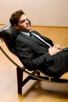 Man lying on chaise longue Stock Photos