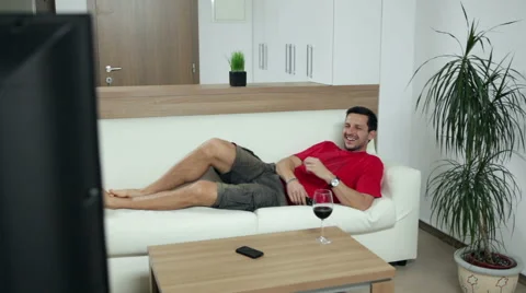 Man lying on couch and watching TV Stock Footage 47249593