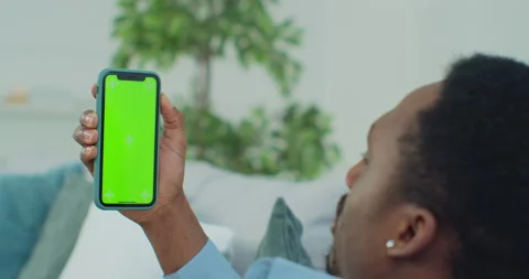Man lying on couch with modern smartphone in his hand while looking on mock up Video stock 151602287