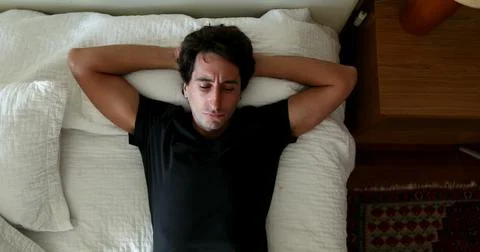 Man lying down in bed thinking about solution to problem. Person taking a d.. Foto stock