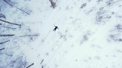 Man lying down making snow angel, top view. Outdoor activities and ecological Stock Footage 293259325