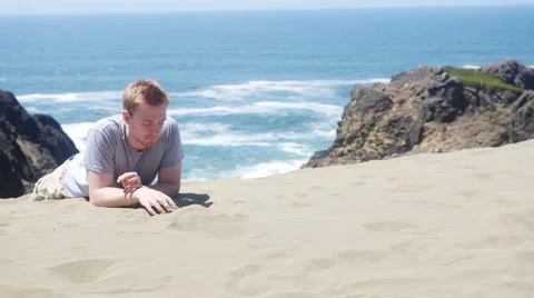 Man lying down on the sand by the beach Stock-Footage 67297793