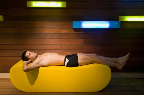 A man lying down in a sauna Stock Photos