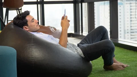 Man lying down using smart phone on sofa Stock Footage 111703593