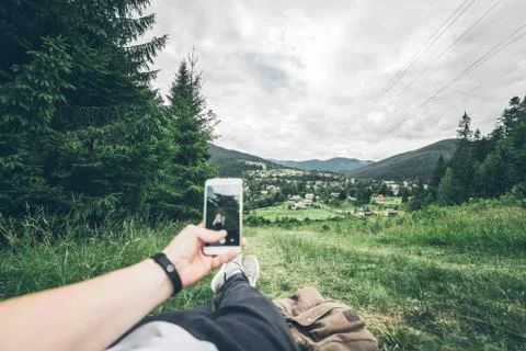 Man lying on the ground and taking picture of mountains Foto stock