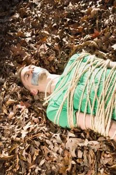 Man lying on the ground, bound in rope and with adhesive tape covering his mouth Stock Photos