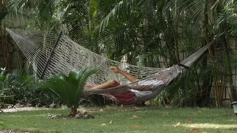 Man lying in a hammock in a hotel. Stock Footage 111538996