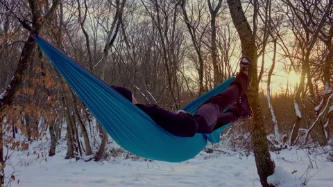 Man lying in hammock under the trees in the winter forest Stock-Footage 146776327