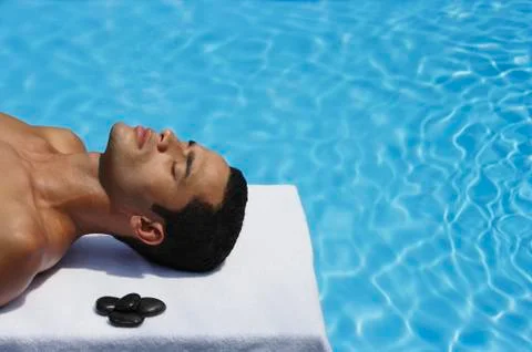 Man lying by pool Stock Photos