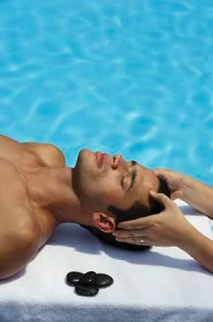 Man lying by pool , receiving massage Stock Photos