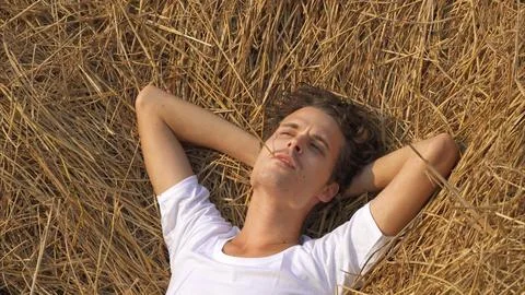 Man is lying relaxed in a haystack Stock Photos