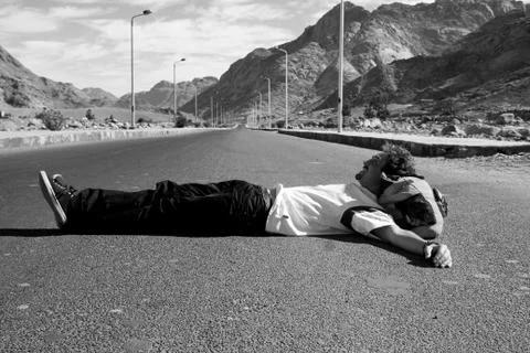 Man lying on road Stock-Fotos