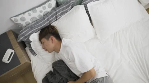 Man lying on side in bed having restless sleep Stock Footage 200443470