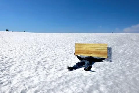 Man lying on the snow in winter with board Stock Photos