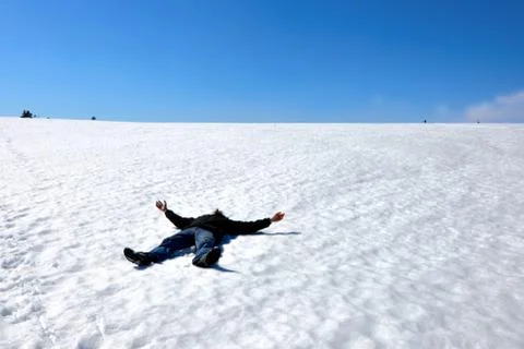 Man lying on the snow in winter Stock Photos