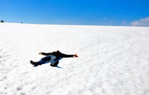 Man lying on the snow in winter Stock Photos